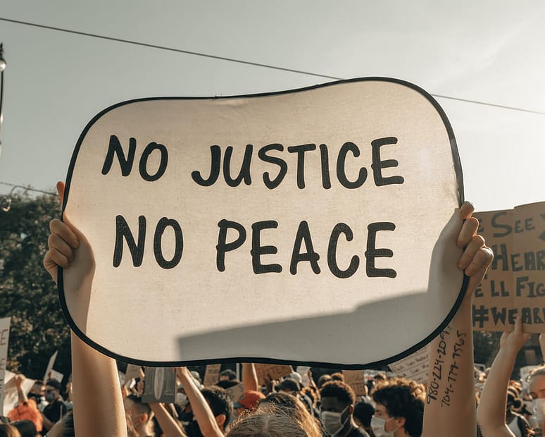 Protestor sign that reads, "No Justice, No Peace"