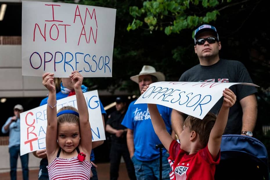 Children holding protest signs saying 'I am not an oppressor'